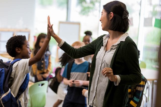 Enseignante et jeune qui se tapent dans la main