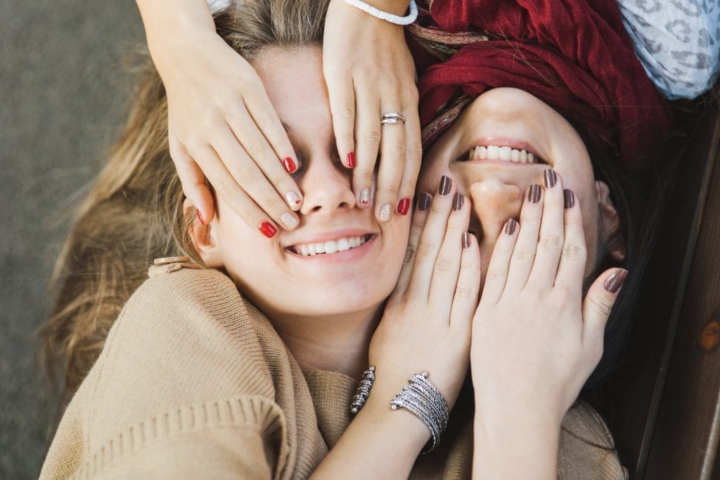 Deux adolescentes qui se cachent les yeux avec leurs mains